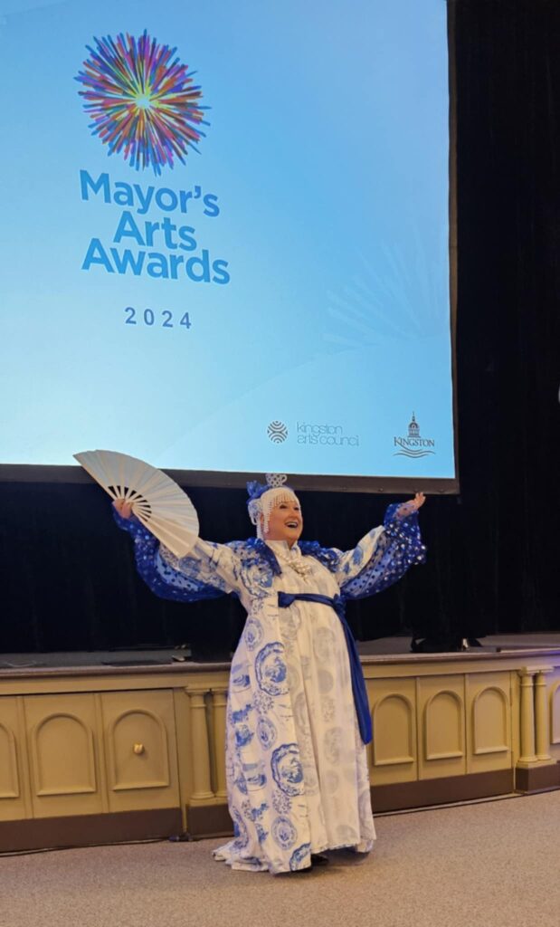 Tyffanie in front of the projector screen with the Mayor's Arts Award 2024 logo